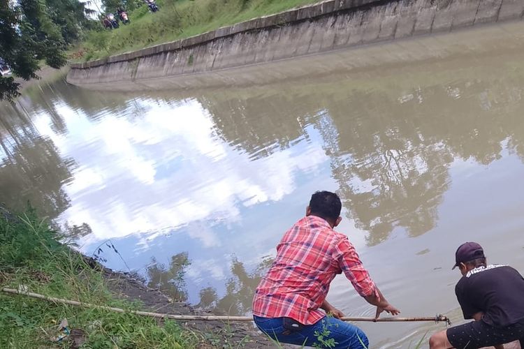 EVAKUASI—Aparat Polsek Jiwan bersama warga mengevakuasi jasad nenek Wagiyem yang ditemukan tewas mengapung di Kanal Desa Teguhan, Kecamatan Jiwan, Kabupaten Madiun, Jawa Timur, Rabu (11/1/2023).