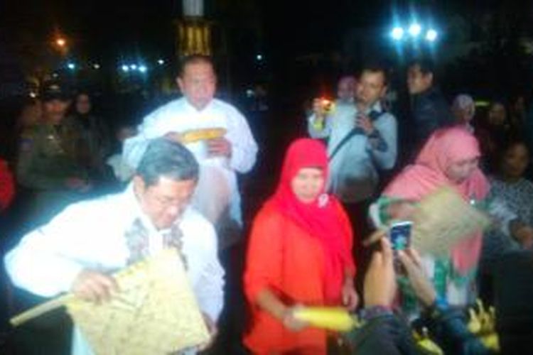 Gubernur Jawa Barat Ahmad Heryawan (paling kiri) dan Istrinya Netty Prasetyani Heryawan (berbaju merah jambu, memegang kipas, kanan), membakar jagung di Gedung Sate, Jalan Diponegoro, Bandung, Jawa Barat, Selasa, (31/12/2013). Sementara, Wakil Gubernur Jabar Deddy Mizwar terlihat sedang melahap jagung yang dibakar Heryawan.