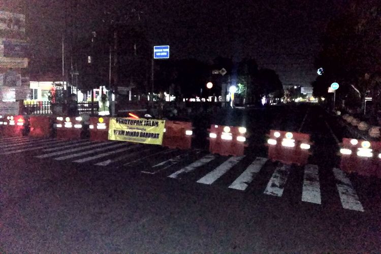 Petugas berjaga di titik penyekatan di depan Kantor DPRD Kota Blitar di Jalan A Yani, Kota Blitar, Senin malam (19/7/2021)