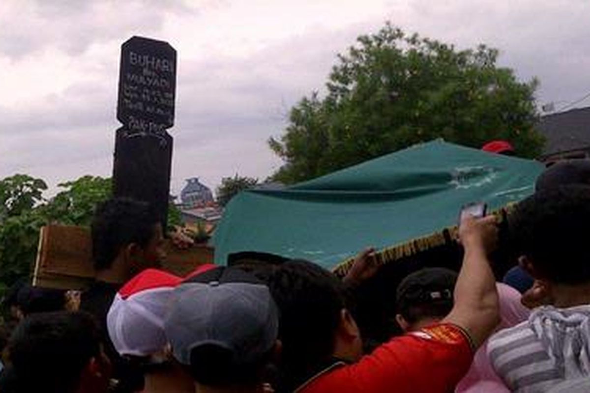 Jenazah Buhari alias Ari (16) diturunkan ke liang lahat di TPU Kawi-Kawi Johar Baru, Jakarta Pusat, Senin (23/1/2012). Dalam waktu hampir bersamaan, jenazah tiga rekannya juga dimakamkan di TPU itu. Keempatnya bersama lima korban lain adalah korban kecelakaan maut yang terjadi di Jalan Ridwan Rais Gambir, Jakarta Pusat, kemarin.