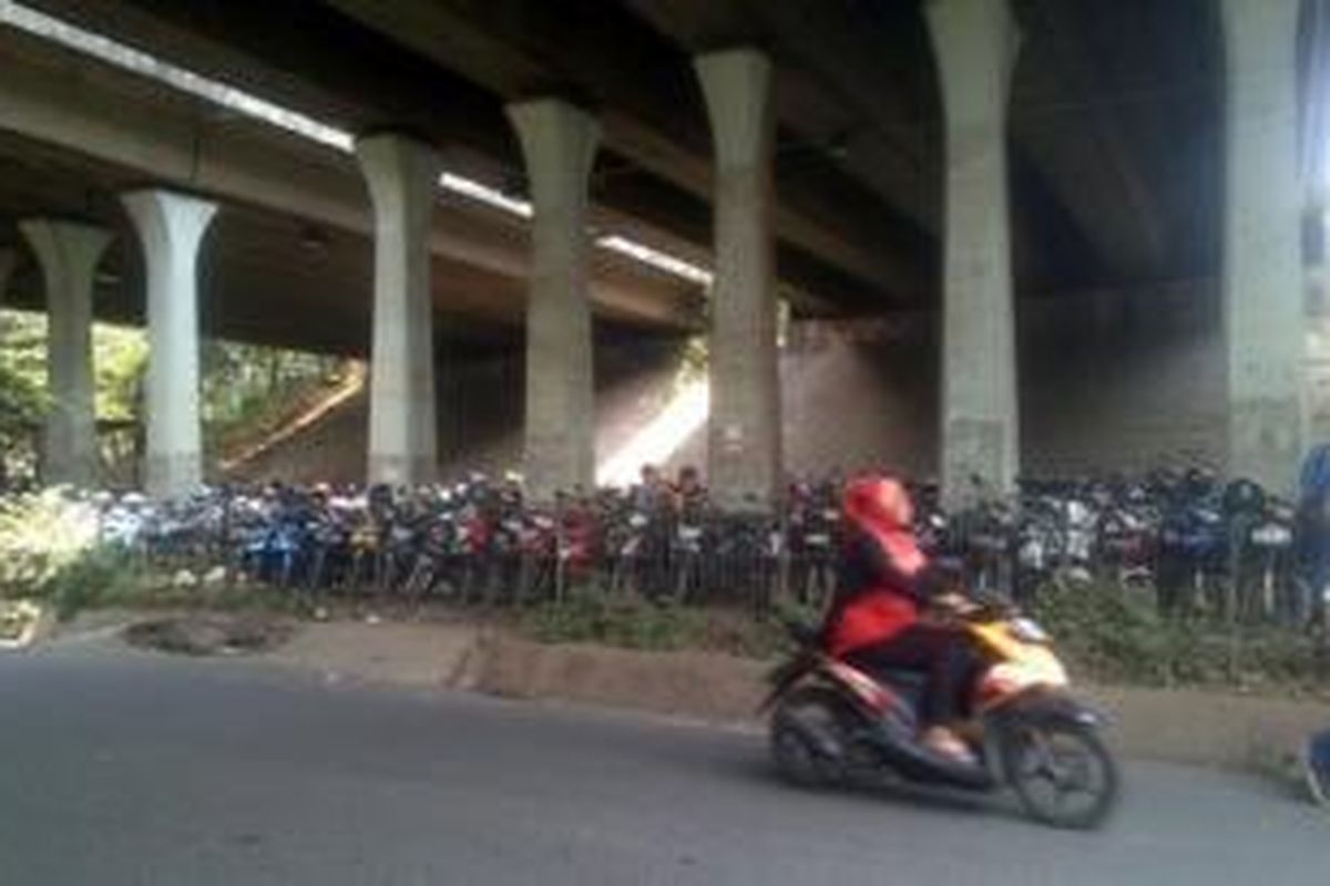 Lahan kosong di kolong tol Cakung yang tadinya taman kini dijadikan tempat parkir sepeda motor. Warga menitipkan sepeda motor untuk melanjutkan perjalanan dengan kereta. 