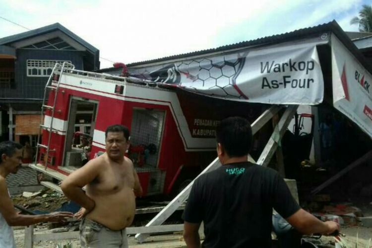Sejumlah warga berupaya mengevakuasi korban luka setelah mobil pemadam kebakaran di Kabupaten Bone, Sulawesi Selatan menabrak warung. Jumat, (14/4/2017).