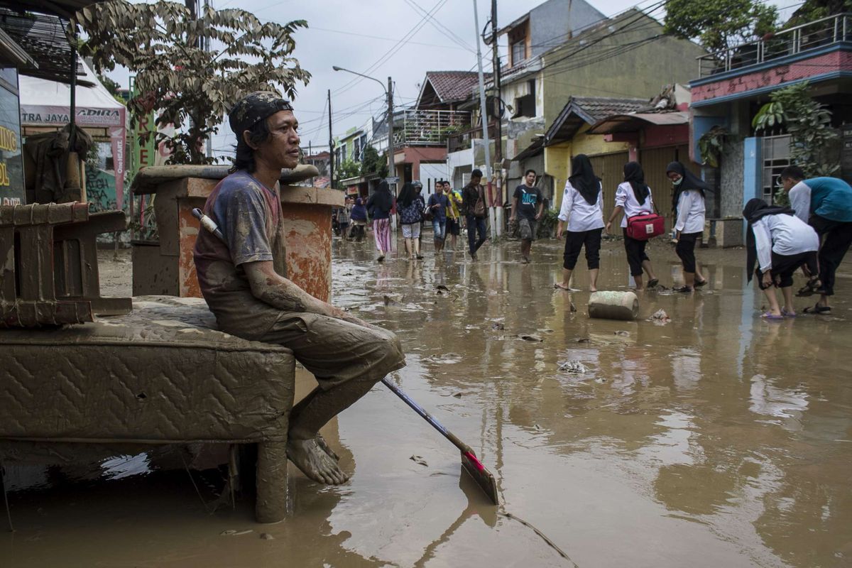 Sejumlah warga beristirahat usai membersihkan ruko miliknya yang sempat terendam banjir di kawasan Pondok Gede Permai, Jati Asih, Bekasi, Jawa Barat, Kamis(2/1/2020). Banjir di kawasan tersebut, merupakan banjir terparah di wilayah Bekasi.