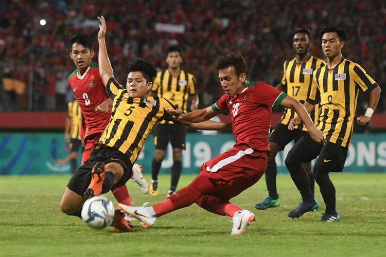Pesepak bola Indonesia U-19 Egy Maulana Vikri (tengah) menendang bola yang dihalangi pesepak bola Malaysia U-19 Muhammad Anwar (kiri) dalam laga semifinal Piala AFF U-19 di Gelora Delta Sidoarjo, Sidoarjo, Jawa Timur, Kamis (12/7/2018). Indonesia kalah adu penalti dari Malaysia dengan skor 3-4.