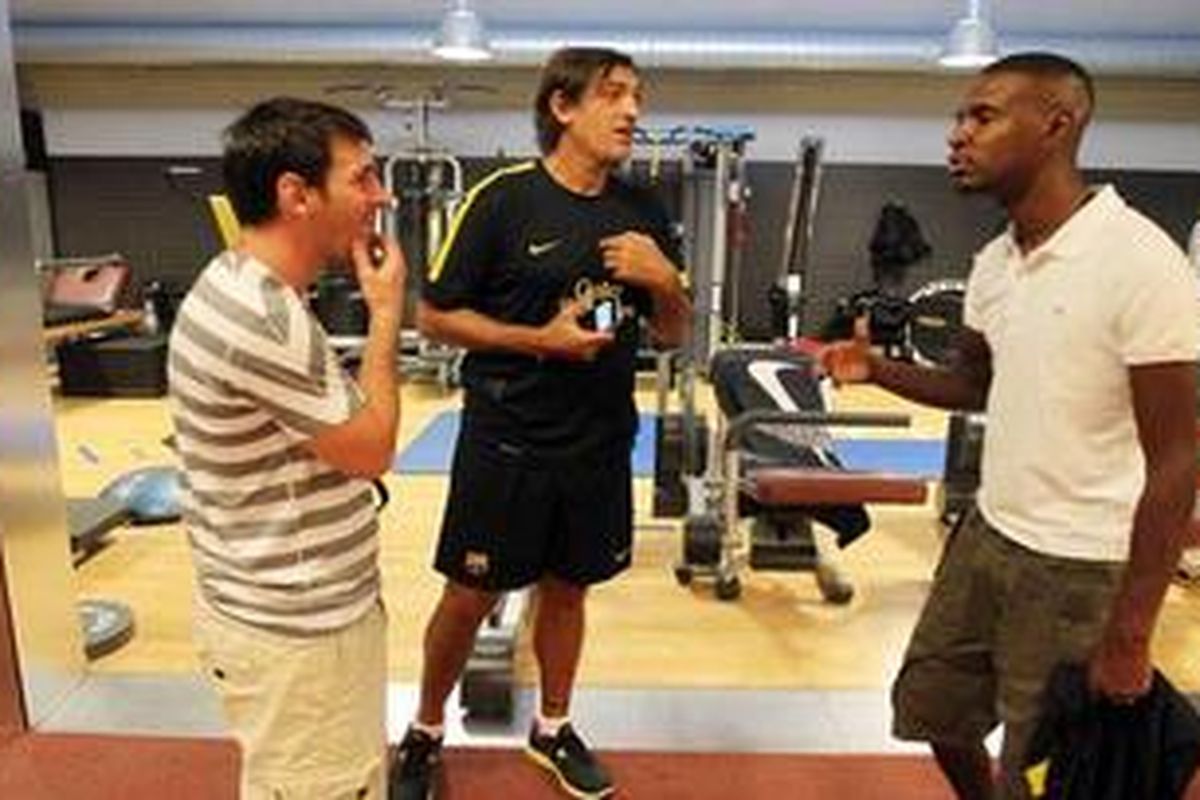 Eric Abidal (kanan) bercengkerama dengan Lionel Messi (kiri) di pusat latihan Barcelona, Ciutat Esportiva.
