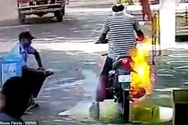Api menjalar di sepeda motor seorang pria ketika disemprot disinfektan