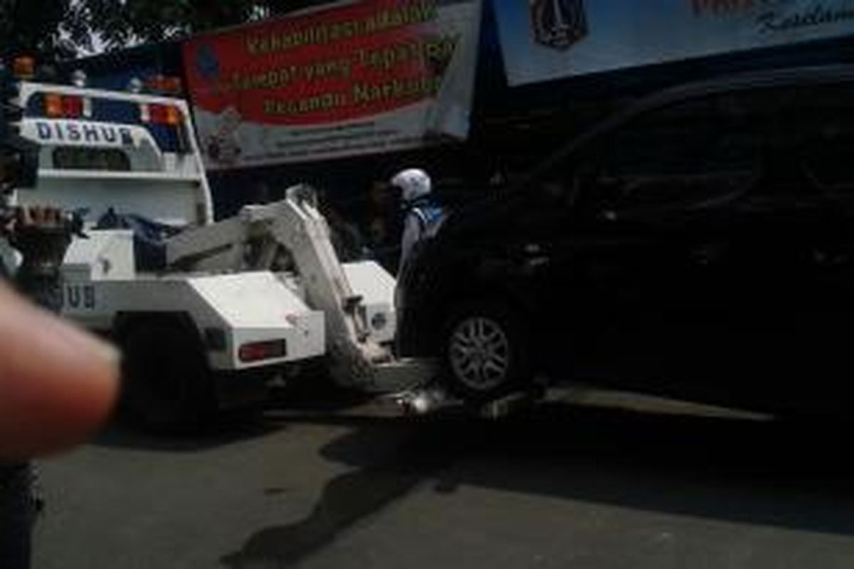 Simulasi kendaraan yang parkir liar diderek oleh Dinas Perhubungan DKI Jakarta.