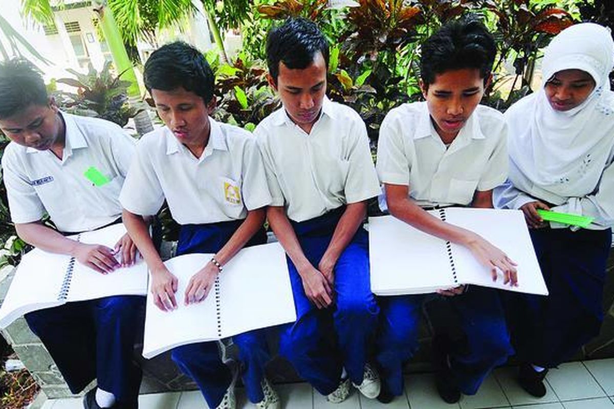 Siswa kelas IX SMPLB Yayasan Pendidikan Anak-anak Buta belajar dengan buku berhuruf braille di luar ruang kelas sebelum mengikuti  ujian nasional di Surabaya, Jawa Timur, Senin (23/4).