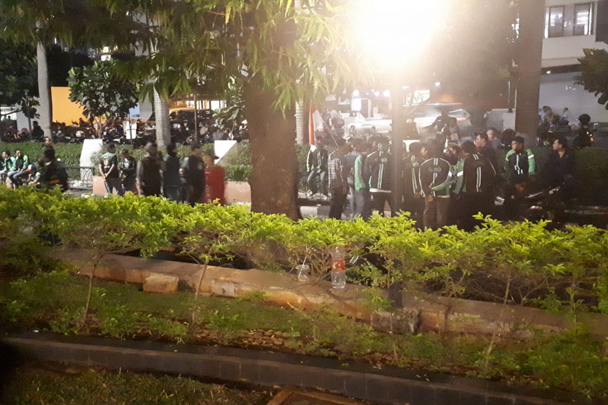 Sekitar 100 pendemo yang memilih untuk bertahan menunggu perwakilan Grab Indonesia. Mereka duduk di sepanjang trotoar depan Gedung Lippo Kuningan, Rabu (19/9/2018).