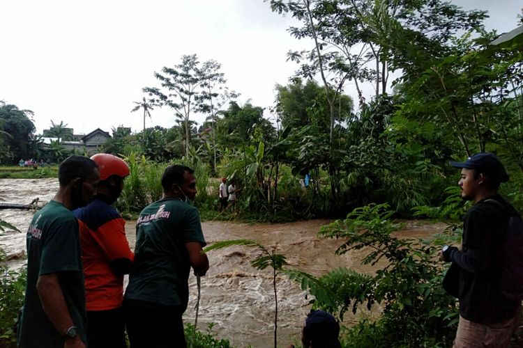 Personel dari unit reaksi cepat BPBD Kabupaten Blitar mengevakuasi dua warga yang terjebak di Sungai Lekso di Kecamatan Wlingi, Kabupaten Blitar, Jumat (8/4/2022) sore