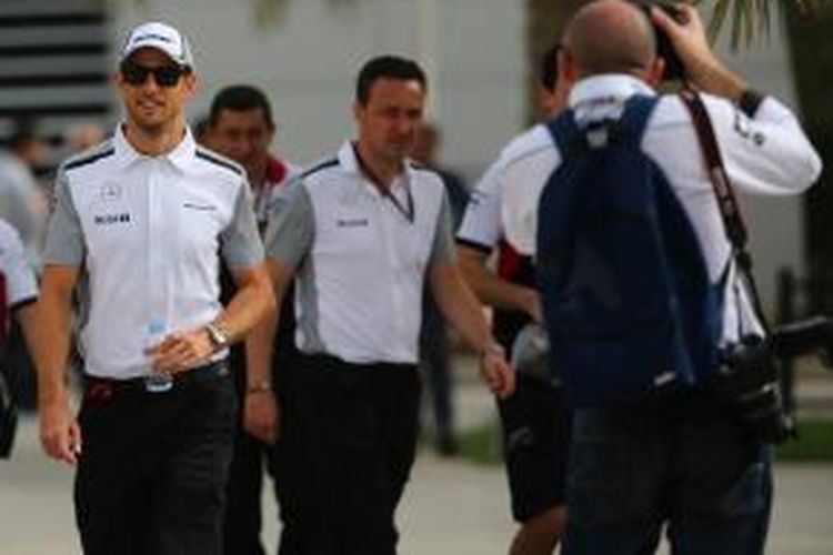 Pebalap McLaren Mercedes asal Inggris, Jenson Button (kiri) berjalan di paddock Sirkuit Internasional Bahrain setelah konferensi pers jelang GP Bahrain, Kamis (3/4/2014).