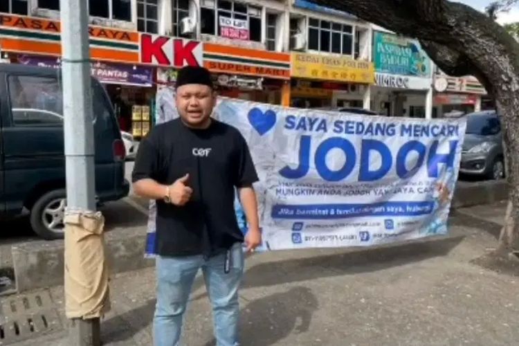 Tangkapan layar dari video pria Malaysia bernama Ariff Luqman yang memasang spanduk pencarian jodoh. Ia menawarkan imbalan 10.000 ringgit (Rp 33,7 juta) bagi yang bisa mendapatkan istri untuknya.