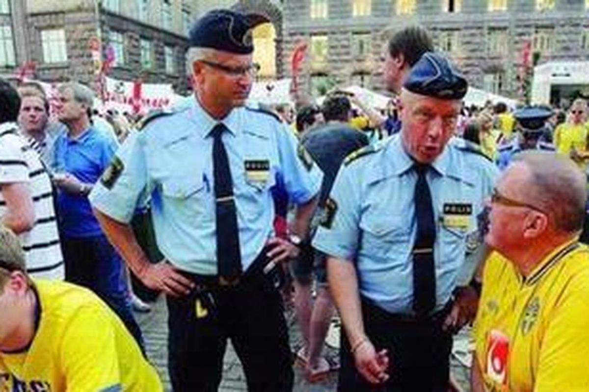 Polisi Swedia berbincang dengan pendukung Swedia di fan zone hari Kamis (14/6) atau sehari menjelang pertandingan Swedia melawan Inggris di Kiev, Ukraina, hari Jumat (15/6). Swedia dan Inggris membutuhkan kemenangan untuk membuka peluang lolos dari grup.