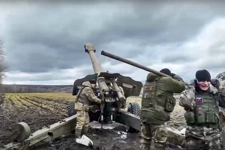 Tentara Rusia menembakkan senjata howitzer kepada pasukan Ukraina di lokasi yang tak disebutkan. Foto ini dirilis Kementerian Pertahanan Rusia pada 22 Maret 2023.