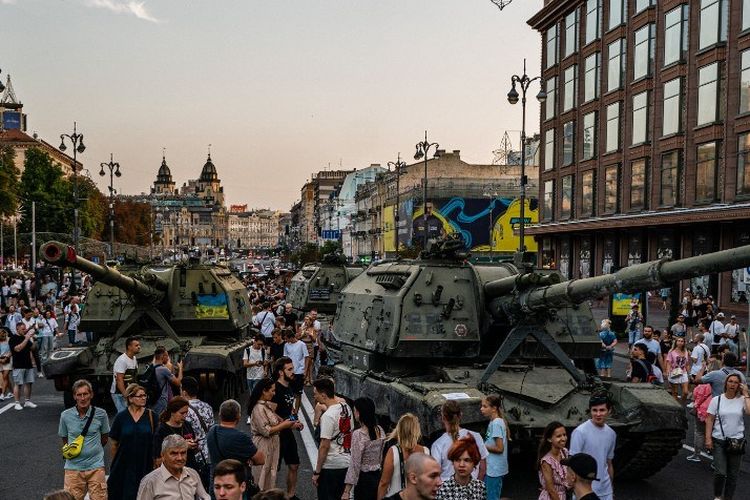 Dalam foto yang diambil pada 21 Agustus 2022 ini, orang-orang melihat peralatan militer Rusia yang hancur di jalan Khreshchatyk di Kyiv, yang telah diubah menjadi museum militer terbuka menjelang Hari Kemerdekaan Ukraina pada 24 Agustus, di tengah invasi Rusia ke Ukraina. (Foto oleh Dimitar DILKOFF / AFP)