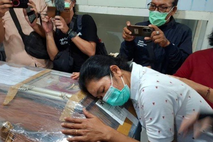 Ibu dari Putu Satria, Ni Nengah Rusmini saat bersandar di peti putranya, Minggu 5 Mei 2024. Isak tangis mengiringi kepulangan jenazah Putu Satria Ananta Rustika (19) di Klungkung, Bali. (Tribun Bali/Eka Mitra Suputra)