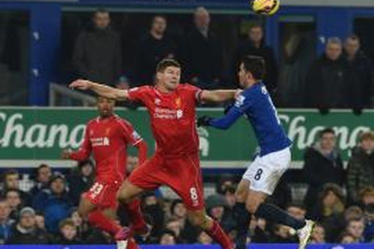 Kapten Liverpool, Steven Gerrard (kiri) saat berebut bola dengan gelandang Everton, Bryan Oviedo, pada laga lanjutan Premier League di Goodison Park, Sabtu (7/2/2015). 