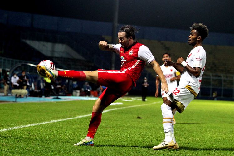 Persija Jakarta Marc Klok menghalau bola dari pemain muda PSM Makasaar Yacob Sayuri saat laga perdana babak penyisihan grup B Piala Menpora 2021 yang berakhir dengan skor 0-2 di Stadion Kanjuruhan Kabupaten Malang, Jawa Timur, Senin (22/03/2021) malam. 