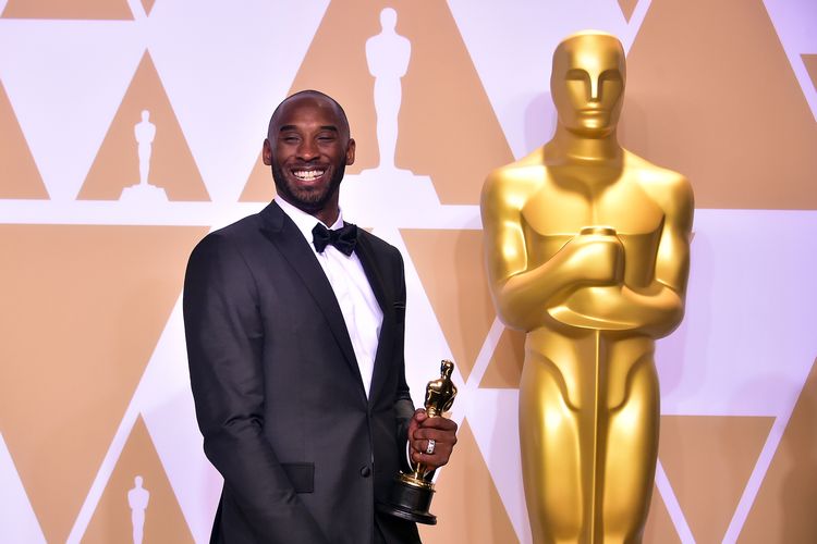 Kobe Bryant berpose dengan piala Oscar untuk Best Animated Short Film dalam film Dear Basketball pada perayaan Academy Awards, 4 Maret 2018 di Hollywood, California. 