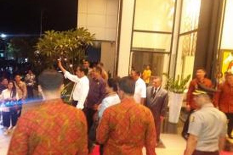 Presiden Jokowi sedang berdiri di depan Hotel Sotis sambil melambaikan tangan kepada ratusan warga Kota Kupang yang berjejal di pinggir jalan. Minggu (27/12/2015)
