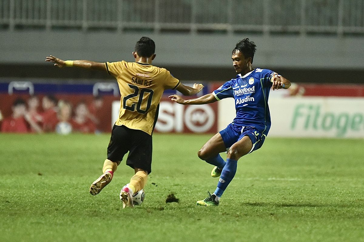 Gelandang Persib Robi Darwis mencoba mengadang laju pemain Bhayangkara FC Sani Rizki Fauzi dalam pertandingan tunda pekan ke-18 Liga 1 2022-2023. Laga Persib Bandung vs Bhayangkara FC digelar di Stadion Pakansari, Cibinong Kabupaten Bogor, Jumat (24/3/2023).
