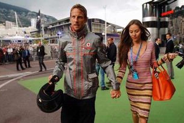 Pebalap McLaren Mercedes, Jenson Button, menggandeng kekasihnya, model asal Jepang, Jessica Michibata, setelah menyelesaikan sesi kualifikasi GP Monako, Sabtu (25/5/2013).