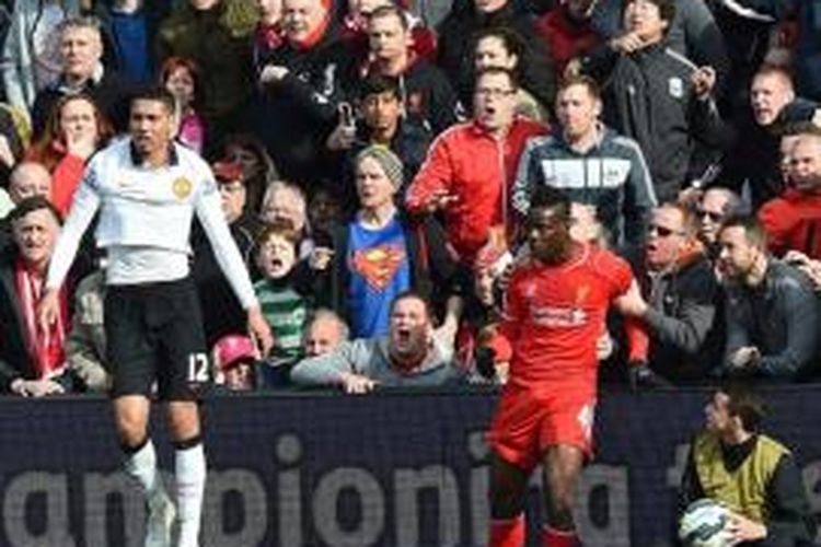 Penyerang Liverpool, Mario Balotelli, bersitegang dengan bek Manchester United, Chris Smalling, saat kedua tim bertemu pada pertandingan lanjutan Premier League, Minggu (22/3/2015). 