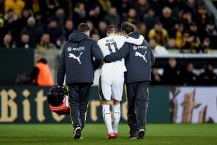 Gelandang Borussia Dortmund, Marco Reus, harus dipapah ke luar lapangan karena mengalami cedera pada laga perdelapan final DFB Pokal melawan Dynamo Dresden, di Glucksgas Stadium, Selasa atau Rabu (4/3/2015) dini hari WIB. 