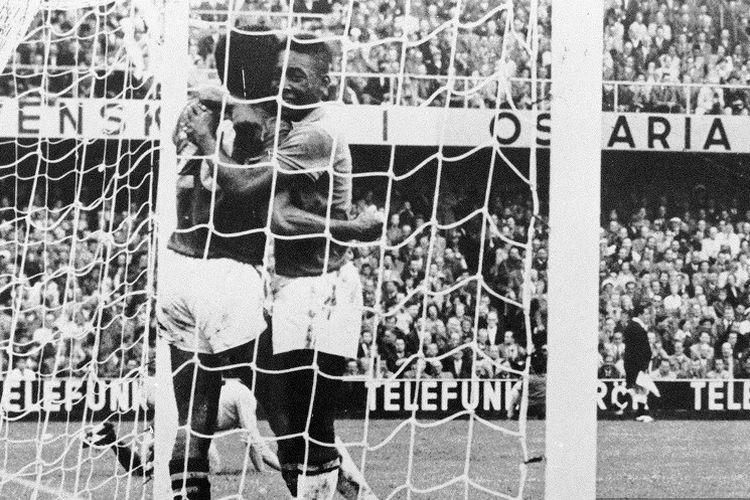 Penyerang Brasil Pele (tengah) mengucapkan selamat kepada rekan setimnya Vava (kiri) setelah mencetak gol ke gawang Swedia yang dijaga Karl Svensson, pada final Piala Dunia 1958, 28 Juni 1958, Stockholm. Basil ketika itu menang 5-2 atas Swedia dan berhasil menjadi juara Piala Dunia untuk pertama kalinya. Pada laga final antara Swedia dan Brasil, Vava dan Pele masing-masing mencetak dua gol. (Photo by STAFF / AFP)