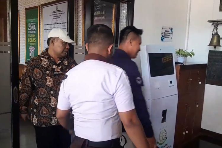 DIPERIKSA—Anggota DPRD Kabupaten Ngawi, Winarto ( bertopi) saat hendak pertama kali diperiksa di Kejari Ngawi, Senin (5/5/2025).