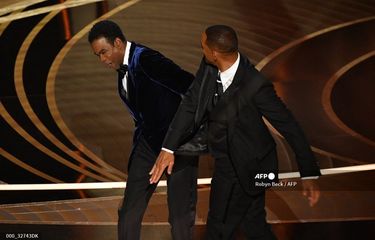 Aktor Will Smith (kanan) menampar koleganya Chris Rock di panggung Oscar yang digelar di Dolby Theatre di Hollywood, California, Minggu (27/3/2022).