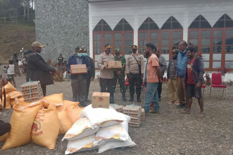 Bupati Intan Jaya Natalis Tabuni bersama Kapolres Intan Jaya I Wayan G Antara menyerahkan bantuan bahan pokok ke pengungsian warga di Komplek Pastoean Gereja Katolik Santo Mikael, Distrik Sugapa, Intan Jaya, Papua, Kamis (12/2/2021)