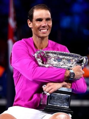 Rafael Nadal smiles and hugs the Australian Open trophy. 