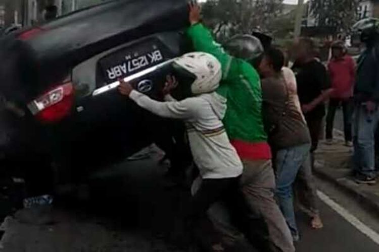 Tangkapan layar video mobil sedan yang terbalik setelah menabrak mobil pick up di Jalan Brigjend Katamso, Kelurahan Sei Mati, Kecamatan Medan Maimun. Kecelakaan lalu lintas terjadi di depan Gang Perwira, Jalan Brigjend Katamso, Kelurahan Sei Mati, Kecamatan Medan Maimun, pada Jumat (19/2/2021) siang. Mobil Toyota Vios terbalik di tengah jalan setelah menabrak mobil pick up Gran Max yang parkir di pinggir jalan dan menyeret dua sepeda motor serta membuat kaca di sebuah rumah pecah.