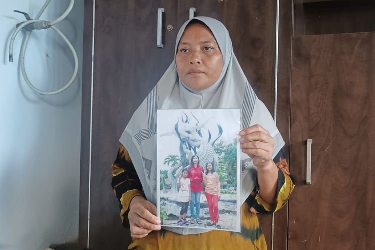 Suliana, kakak ipar Salmiati Ningsih menunjukkan foto Salmiati Ningsih bersama kedua anaknya.