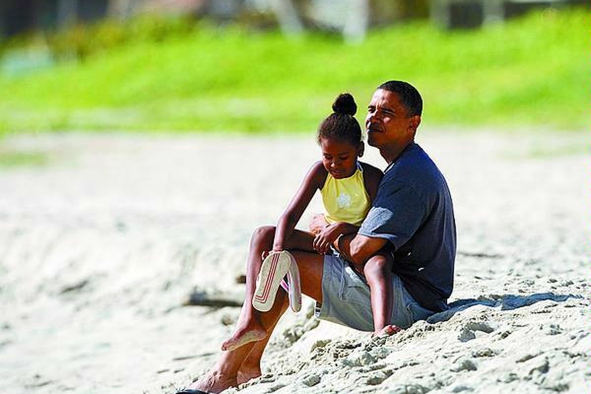 Calon presiden AS dari Partai Demokrat, Barack Obama, dan putrinya, Sasha (7), duduk bersantai di Pantai Kailua di Kailua, Hawaii, AS, Selasa (12/8). Obama berada di Hawaii guna mengunjungi sanak keluarganya sekaligus ke tempat kelahirannya.  