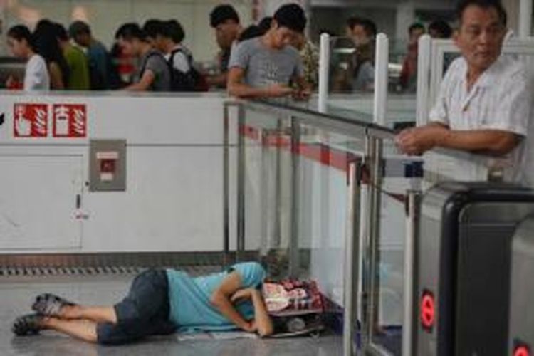 Seorang pria beristirahat di lantai, dan orang-orang berlindung dari panas di stasiun subway di Shanghai, 31 Juli 2013. Sebanyak 10 orang telah tewas di pusat bisnis China karena suhu panas tertinggi dalam 140 tahun terakhir.