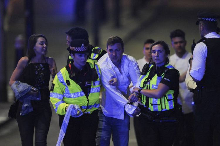 Aparat kepolisian membantu warga yang menjadi serangan teror di London Bridge, Sabtu malam (3/6/2017).  