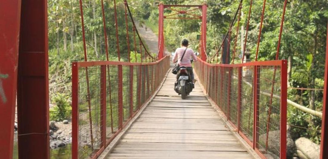 Pengunjung melintasi jembatan di Sungai Gelar, Kabupaten Jembrana, Bali.