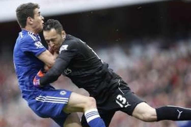 Gelandang Chelsea Oscar (kiri) bertabrakan dengan kiper Arsenal David Ospina (kanan) pada laga Premier League di Stadion Emirates, London, Minggu (26/4/2015).