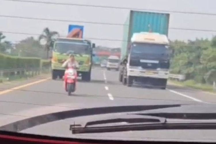 Pengendara motor wanita saat masuk jalan tol Tangerang Merak. Dia melaju di jalur cepat yang dapat membahayakannya.