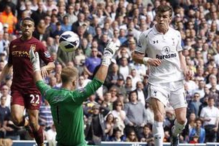 Gelandang serang Tottenham Hotspur, Gareth Bale, saat menaklukkan kiper Manchester City, Joe Hart, pada laga di White Hart Lane, London, Minggu (21/4/2013).