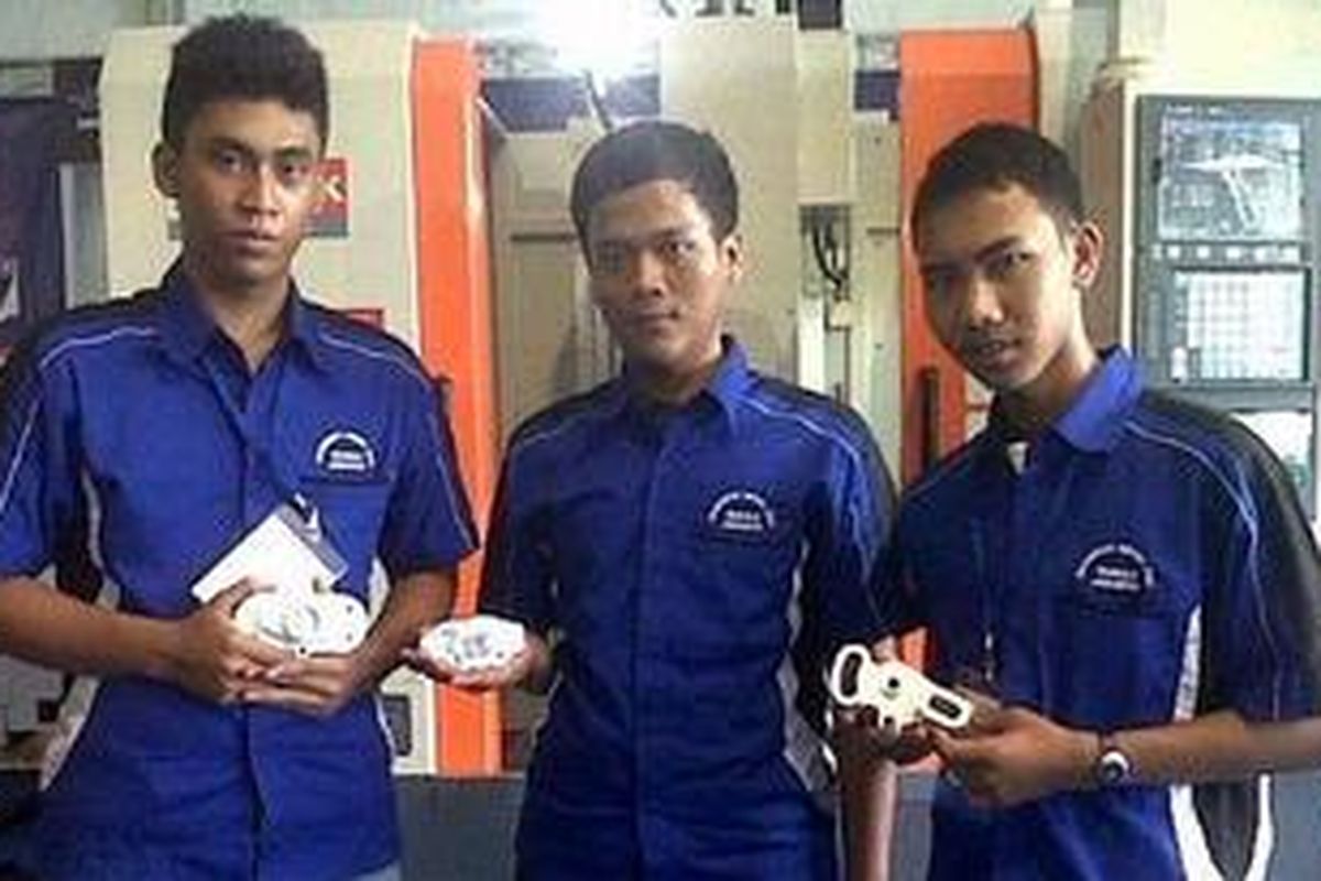 Hanafi (paling kanan), siswa SMKN 5 Jakarta, berfoto di depan CNC Milling, mesin pembentuk benda apa saja yang memiliki tingkat presisi sangat akurat.