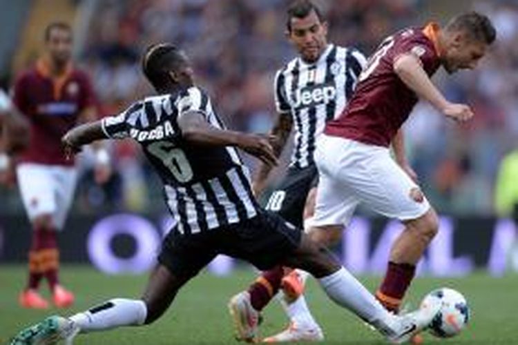 Gelandang Juventus, Paul Pogba, saat berusaha menjegal laju kapten AS Roma, Francesco Totti, pada lanjutan Serie-A di Stadion Olimpico, Minggu (11/5/2014). 