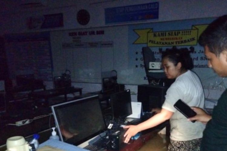 Petugas menunjukkan komputer di kantor pembuatan SIM Sampang yang tergenang banjir akibat banjir luapan Sungai Kalikamuning yang menggenangi wilayah itu dan hingga Senin (2/1/2023) masih berlangsung. 