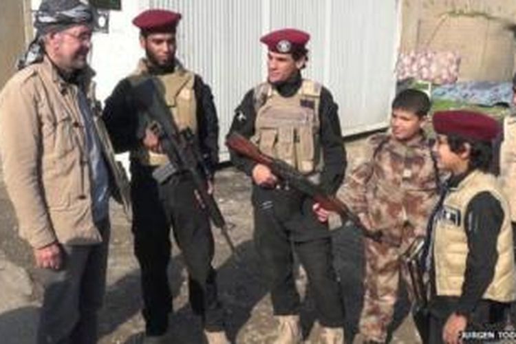 Jurnalis Jerman Jurgen Todenhofer (kiri) saat berbincang dengan dua anggota polisi ISIS dan beberapa anak-anak yang menyandang senjata api di kota Mosul, Irak. Jurgen menghabiskan 10 hari di wilayah utara Irak yang dikuasai ISIS itu.