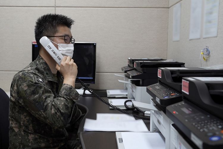 Foto dari Kementerian Pertahanan Korea Selatan memperlihatkan seorang petugas militer yang tak disebut namanya melakukan uji coba panggilan dengan petugas Korea Utara, melalui hotline lintas perbatasan yang dibuka kembali setelah lebih dari setahun terputus, pada Senin (4/10/2021).