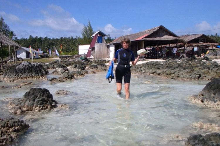 Helga, wisatawan asal Jerman, sedang mengitari batu-batu terumbu karang yang muncul ke permukaan yang ada di sepanjang Pantai Tureloto, Nias Utara, Sumatera Utara.