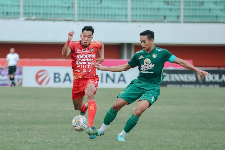 Pemain Bali United Made Tito dijaga ketat pemain Persebaya Surabaya saat pertandingan pekan ke-25 Liga 1 2022-2023 yang berakhir dengan skor 4-0 di Stadion Maguwoharjo Sleman, Sabtu (18/2/2023) sore. 
