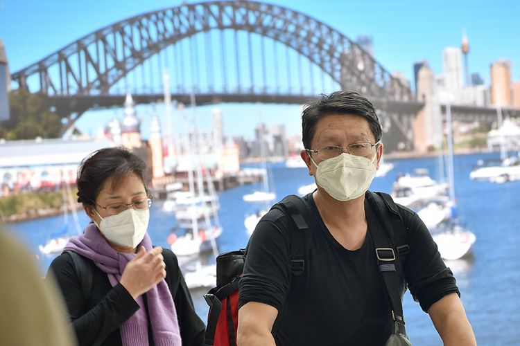 Penumpang mengenakan masker tiba di Bandara Sydney, Australia, setelah mendarat dengan pesawat dari Kota Wuhan, China, Kamis (23/1/2020). Hingga saat ini, sudah 12 negara di berbagai belahan Bumi yang positif mengumumkan terdampak virus corona yang dilaporkan sudah menjangkiti 1.300 orang dan membunuh 41 orang di China.